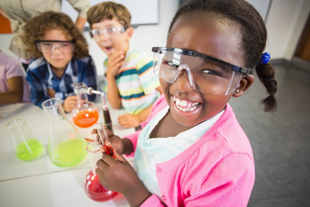 Students in safety goggles doing a hands-on science experiment